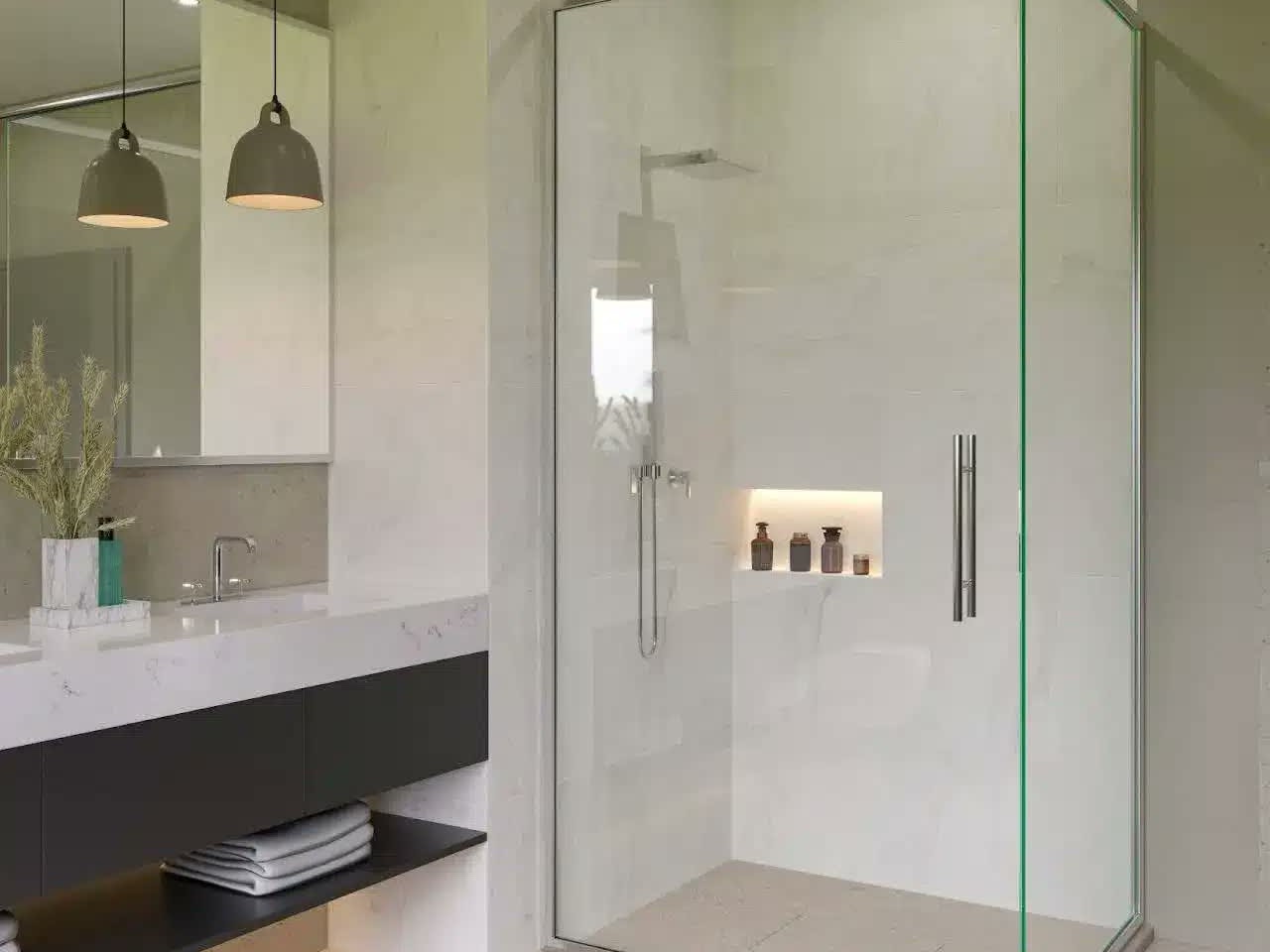 A new semi-frameless shower screen with a slim frame and a long pull handle in a stone-tiled bathroom